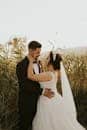 Bride and groom embracing outdoors during a picturesque sunset ceremony.