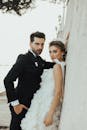 A sophisticated bride and groom pose elegantly against a wall in İstanbul.