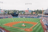 Vibrant baseball game at Dodger Stadium with packed stands and players on the field.