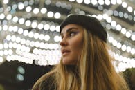 Artistic portrait of a woman with festive bokeh lights in the background, creating a magical mood.