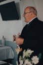 A priest holds a chalice during a holy mass ceremony indoors, captured in candid profile view.