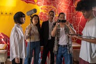 Film crew in action capturing an indoor movie scene with microphones and cameras, diverse cast.