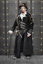 Elegant steampunk fashion with a detailed costume, mask, and cane.