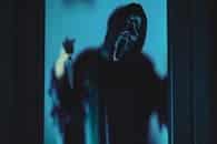 Eerie ghostface figure in blue lighting, ideal for Halloween themes.