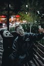 Two masked individuals in a park take a selfie at night, creating a spooky urban scene.