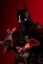 Striking black and red superhero cosplay costume against a vivid red backdrop.