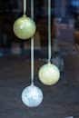 Three globe ornaments hang suspended in a window. Perfect for travel or holiday themes.