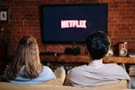 A couple enjoys a relaxed evening watching Netflix in their living room.