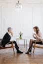 Two women engaged in a counseling session in a bright, modern loft setting.
