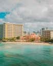 A sunny day at Waikiki Beach with iconic seaside hotels and turquoise waters in Honolulu, Hawaii.