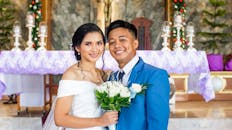 Bride and groom smiling in an elegant church setting, embracing love and happiness.