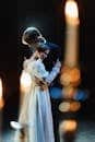 A romantic scene featuring a couple embracing on stage in a theatrical setting, exuding elegance and emotion.