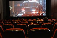 People seated in a cinema watching a movie on a large screen.