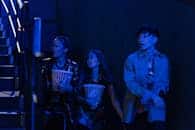 Group of friends with popcorn heading upstairs in a cinema setting.