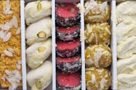 A vibrant collection of Indian sweets featuring almonds, pistachios, and coconut.