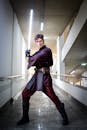 Man in Star Wars cosplay holding a lightsaber, indoors, São Paulo, Brazil.