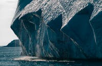 Dramatic close-up view of a melting iceberg in the Arctic ocean, showcasing climate change effects.