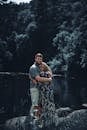 A loving couple embraces by a tranquil forest lake, creating a serene romantic scene.