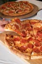 Close-up of a pepperoni pizza slice being served from a freshly baked pizza.