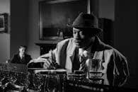 A classic noir scene with a detective taking notes in a dimly lit bar, emphasizing mystery and intrigue.