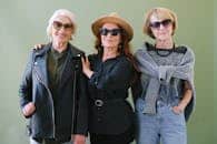 Three senior women in stylish outfits and sunglasses, exuding confidence and elegance.